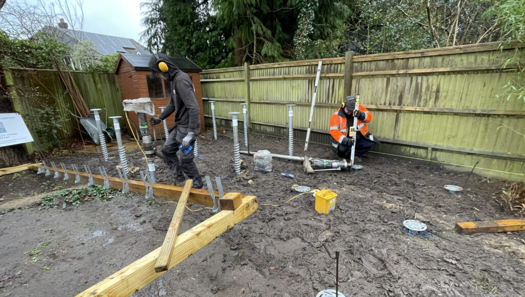 Photo of a wooden frame base and ground screws