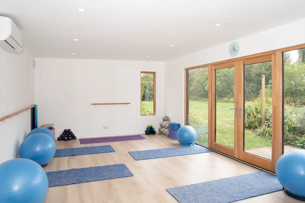 Pilates studio with double doors and mats in place.